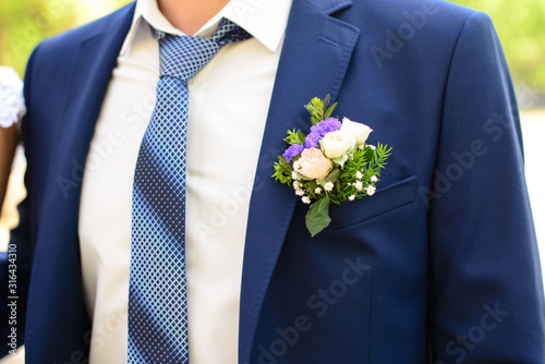 The element of the groom's blue suit with a blue necktie and Boutonniere in his jacket pocket