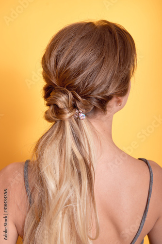 Rear view of female hairstyle middle bun with brown hair.