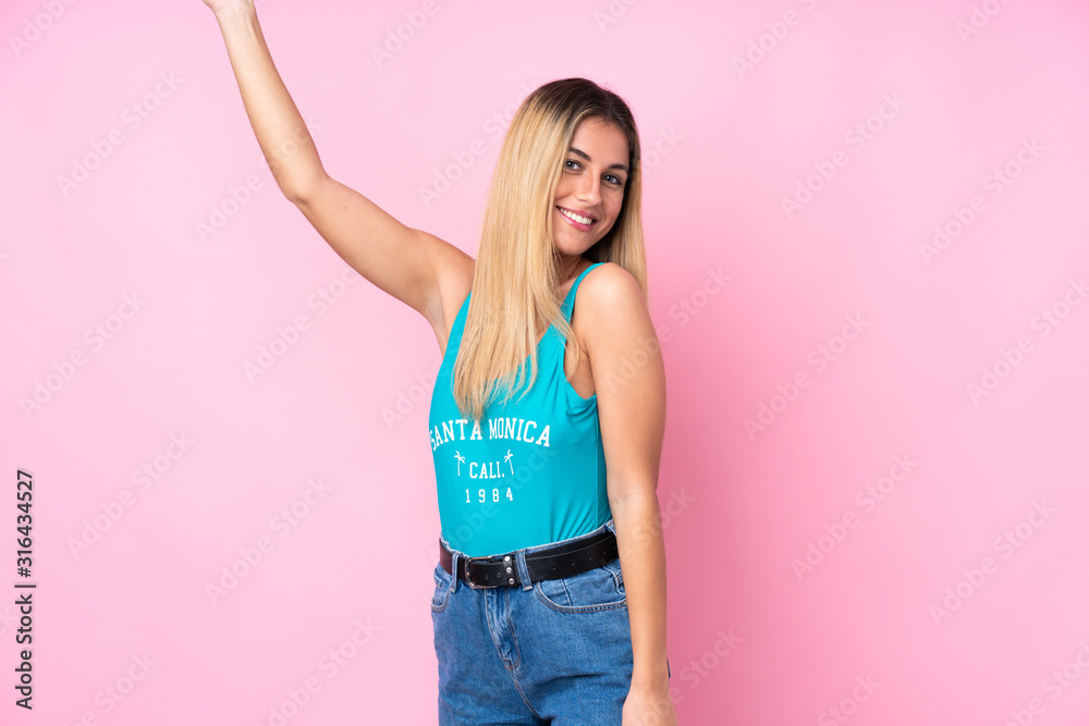 Young blonde Uruguayan woman in swimsuit in summer holidays over isolated pink background Young blonde Uruguayan woman in swimsuit in summer holidays over isolated pink background