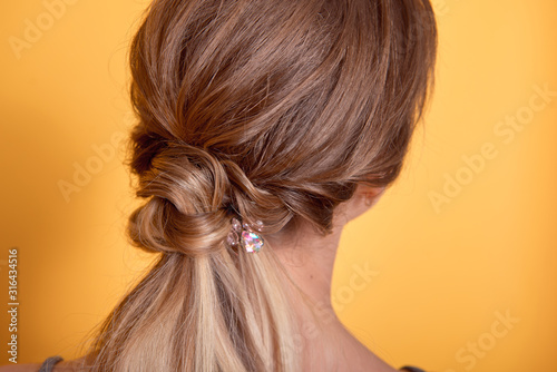 Rear view of female hairstyle middle bun with brown hair.