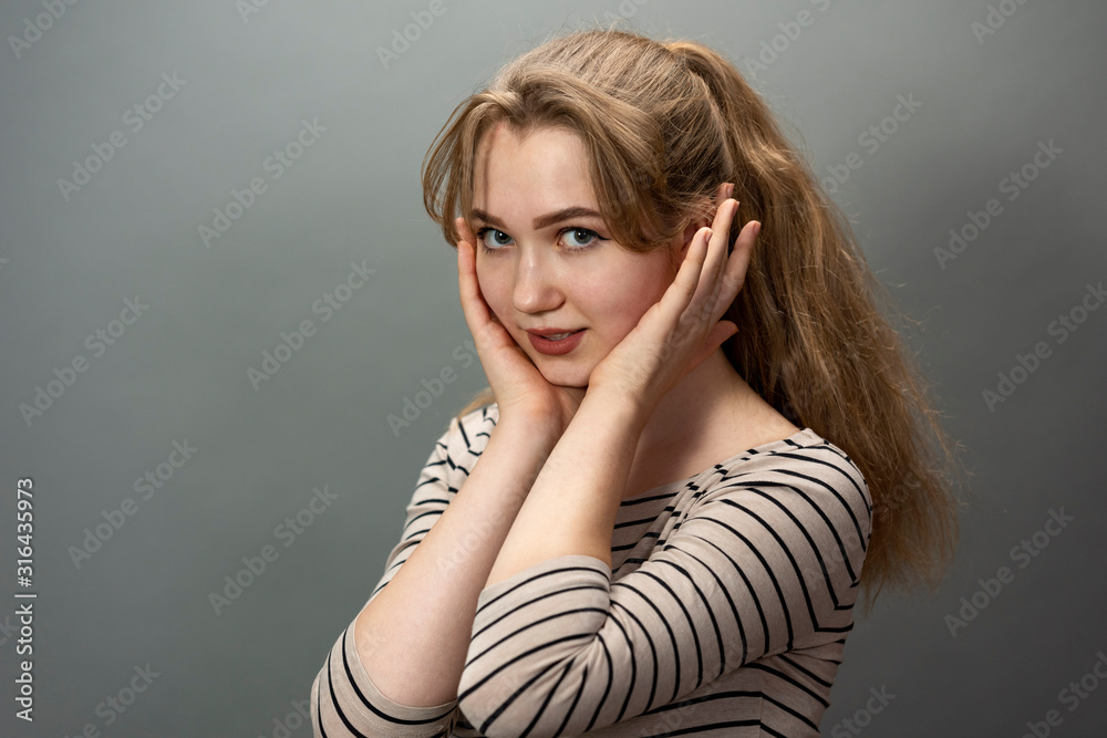 Attractive surprised cute blonde girl portrait on gray background. Attractive surprised cute blonde girl portrait on gray background.
