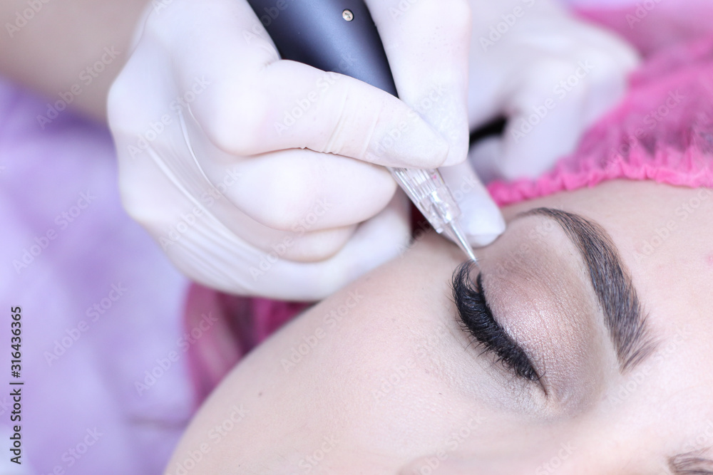 Woman during procedure of permanent make up, close up