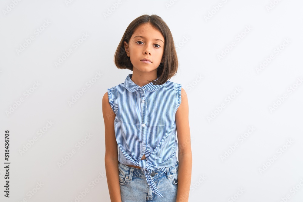 Young beautiful child girl wearing blue casual shirt standing over isolated white background with serious expression on face. Simple and natural looking at the camera. Young beautiful child girl wearing blue casual shirt standing over isolated white background with serious expression on face. Simple and natural looking at the camera.