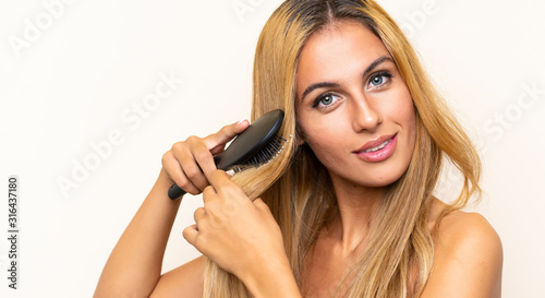 Young blonde woman with hair comb over isolated background