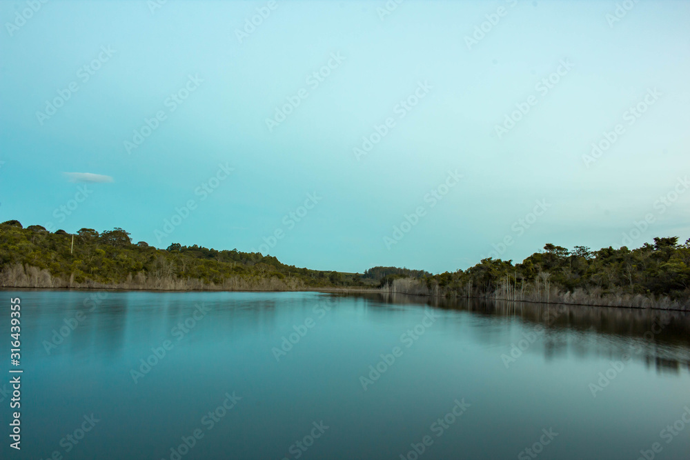landscape with lake and clouds. Pond vegetation with clear skies and crystal clear water. Photo for background.
