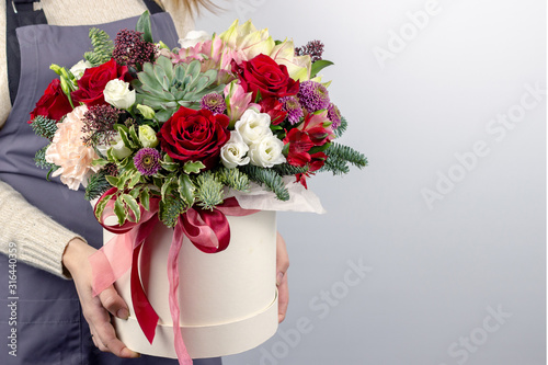 Fototapeta Naklejka Na Ścianę i Meble -  floral fresh arrangement of bright flowers in a hat box copy space white background