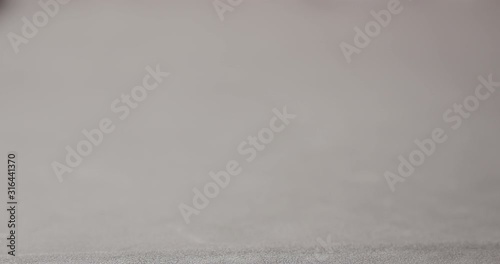Slow motion unroll brown leather piece on walnut table closeup