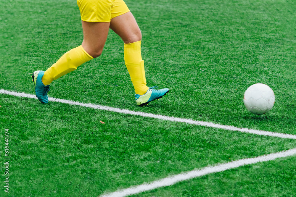 Unrecognizable female soccer players playing a game on the soccer field.