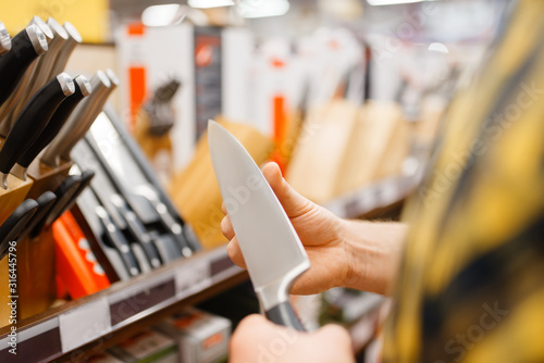 Fotografi Young man choosing kitchen knife, houseware store