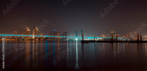San Diego, CA / USA - January 15, 2020: reflections and big trail of light of the San Diego Downtown skyline