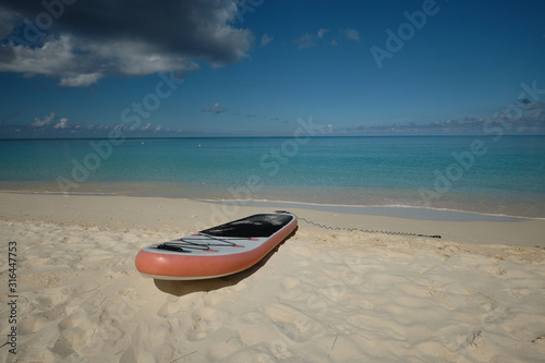 A solitary paddle board sits tethered in the sand on the beach in the Cayman Islands of the British West Indies © Jorge Moro
