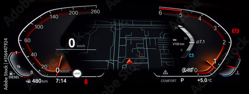 Modern fully digital LCD instrument cluster with navigation screen in center. Car dashboard panel with speedometer, tachometer, fuel and temperature gauge, seat belt reminder, gear position indicator.