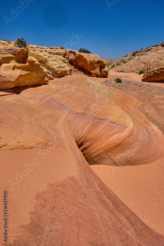 Sand, pebbles and smooth colorful rocks create a gully in the Nevada Desert