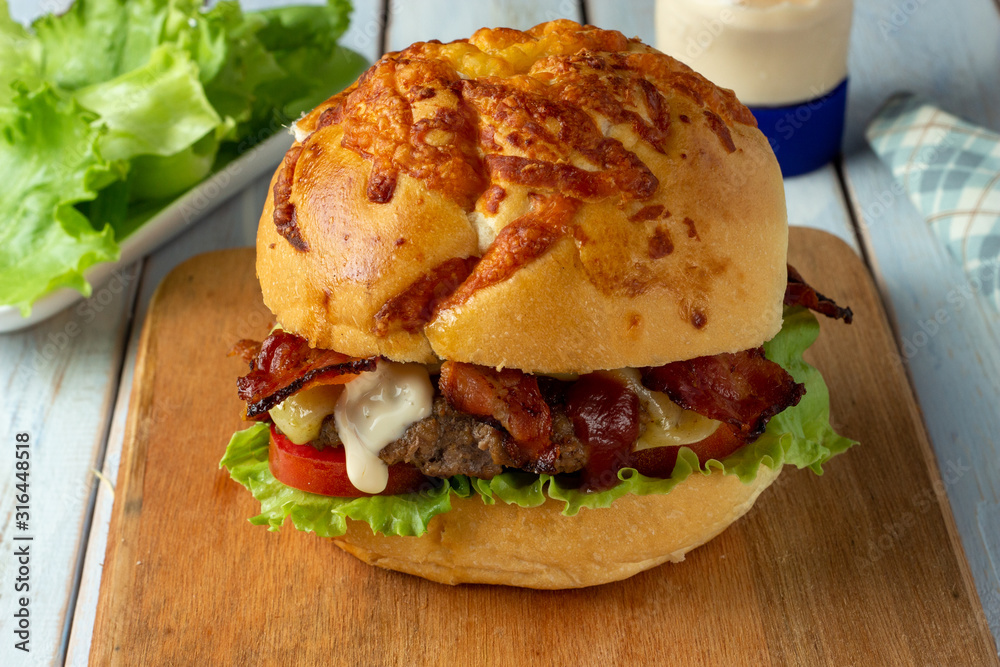 Bacon Cheese Burger with tomato, lettuce and a drop of mayonnaise.