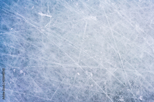 Ice background with marks from skating and hockey, blue texture of rink surface with scratches photo