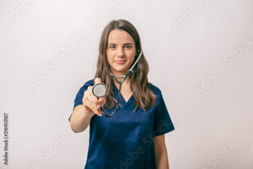 Beutifull young medic woman  holding a stethoscope, isolated over white photo