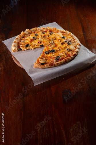 Pizza on a wooden dark background in a bar
