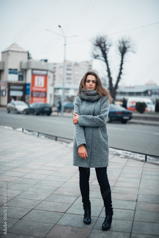 Fototapeta premium Girl in a gray coat in the winter in the city