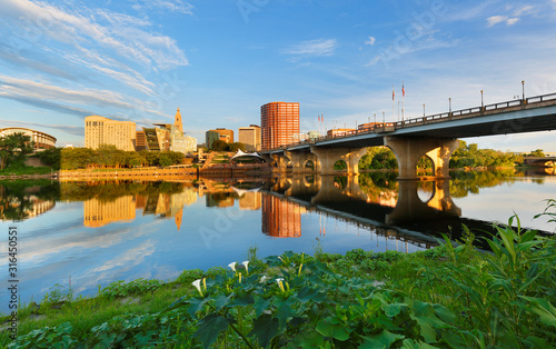 Beautiful sunrise over Connecticut River at Hartford Connecticut. Photo shows the skyline of Hartford, Founders Bridge and Bulkeley Bridge, which  is the oldest  highway bridges  over Connecticut Rive