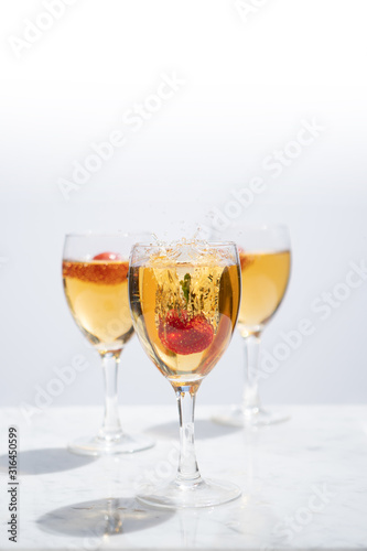 Strawberry Falling into Glass of White Wine with a Splash from the Front with Copy Space