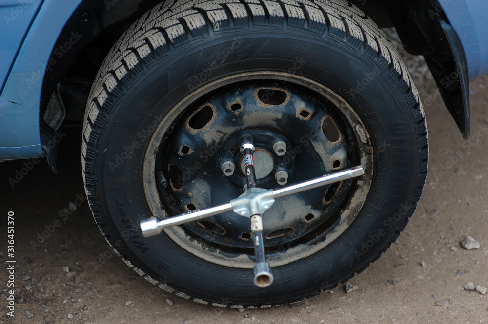 Man is changing tire with wheel on the car