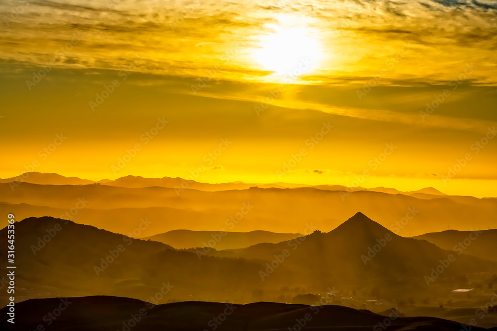 Yellow Sunset over Silhouetted Mountains