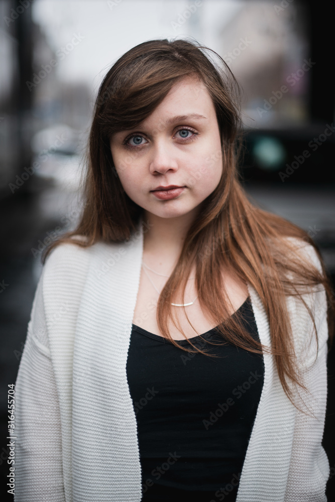 Girl in winter in a cardigan on a street in the city Girl in winter in a cardigan on a street in the city