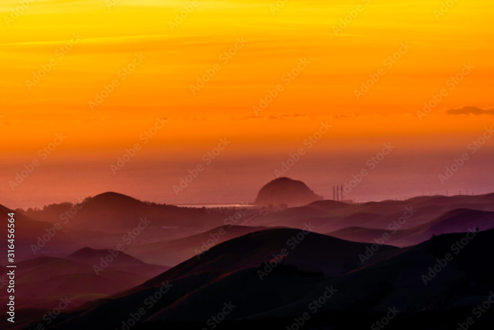 Orange Glow of Sunset over Ocean and Mountains