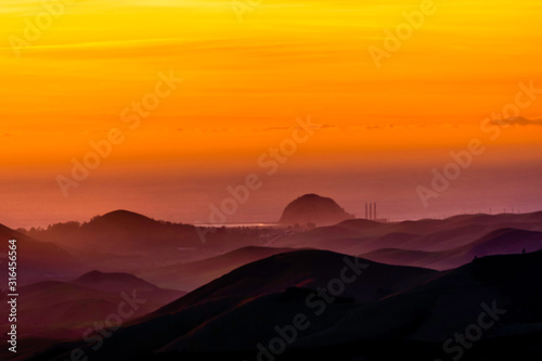 Orange Glow of Sunset over Ocean and Mountains