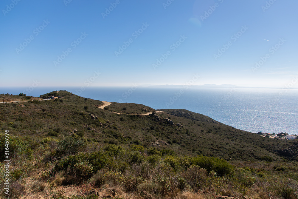 View of a green hill next to the ocean