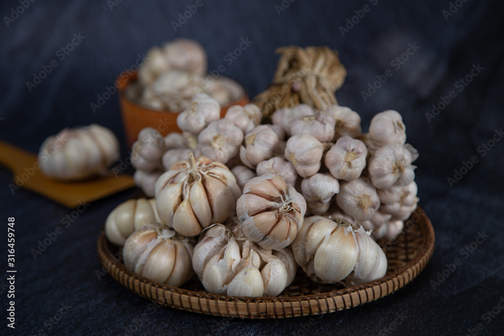 Garlic is placed on the black table in the kitchen, preparing for cooking,