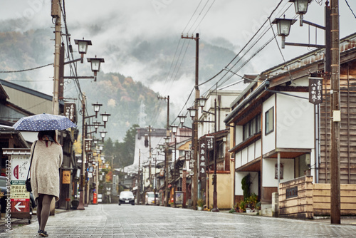 Girl Walking down Street of Traditional Japanese Mountain Town in fog and rain  © Gary