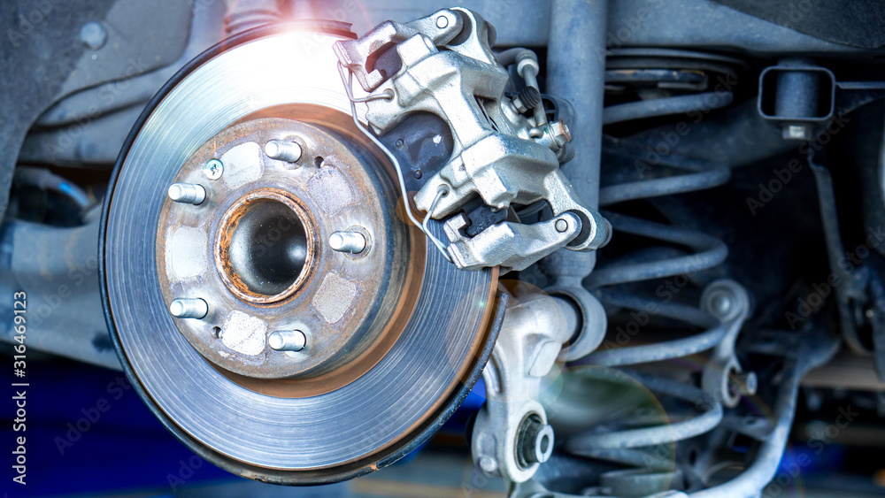 Closeup car disk brake maintenance service in car garage and copy spcae Closeup car disk brake maintenance service in car garage and copy spcae