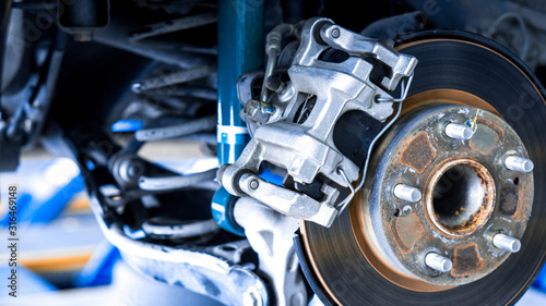 Closeup car disk brake maintenance service in car garage and copy spcae