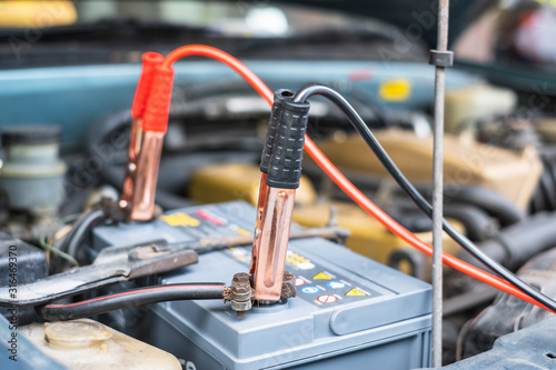Charging a car battery with electricity through cables from another car
