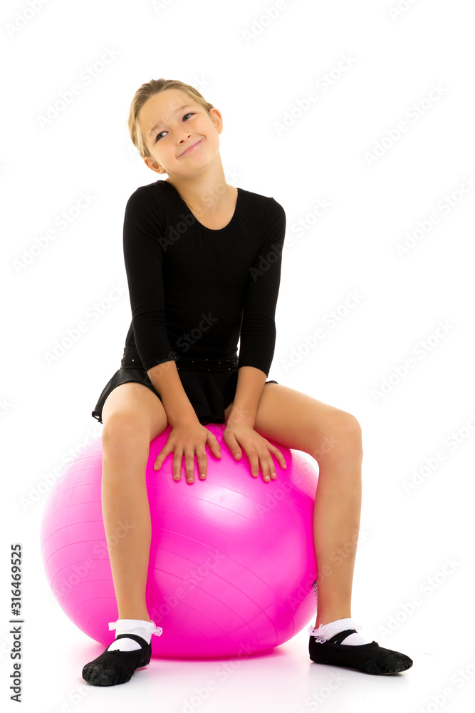 little girl doing exercises on a big ball for fitness. little girl doing exercises on a big ball for fitness.