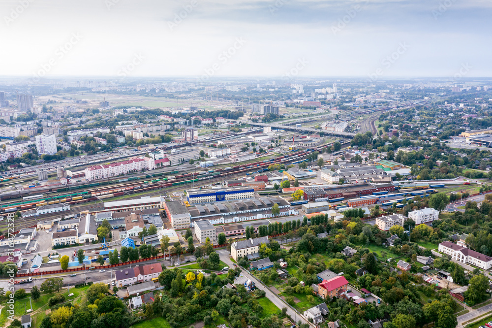 Obraz premium aerial panoramic view of city industrial area with railway hub. freight trains for cargo transportation. Minsk, Belarus