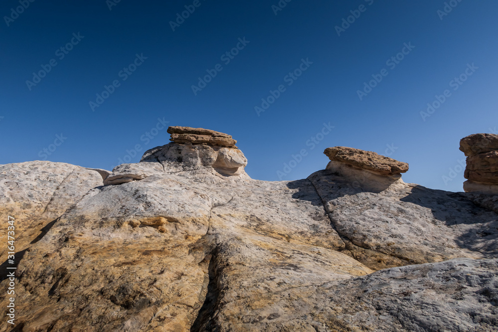 Low angle landscape of large yellow and white rock formations at El Morro National Monument in New Mexico