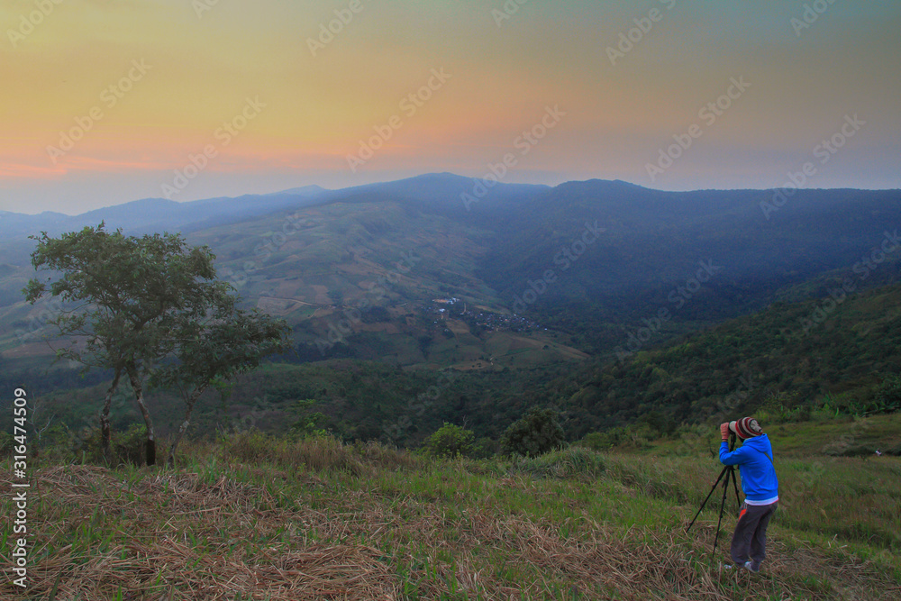 Tourists taking pictures the sky with a tree and hill,Beautiful natural landscape