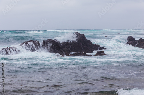 Beautiful Nature scene of sea wave hitting on the black stone shoreline at Jeju Island  South Korea.