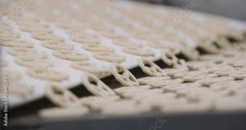 Snacks production Closeup conveyor, raw pretzel ready for baking
