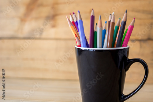 color pencils in pen holder on wooden table