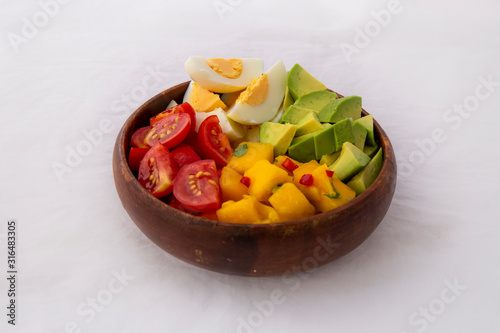 Salad with mango, avocado, egg, romeo tomatoes photo