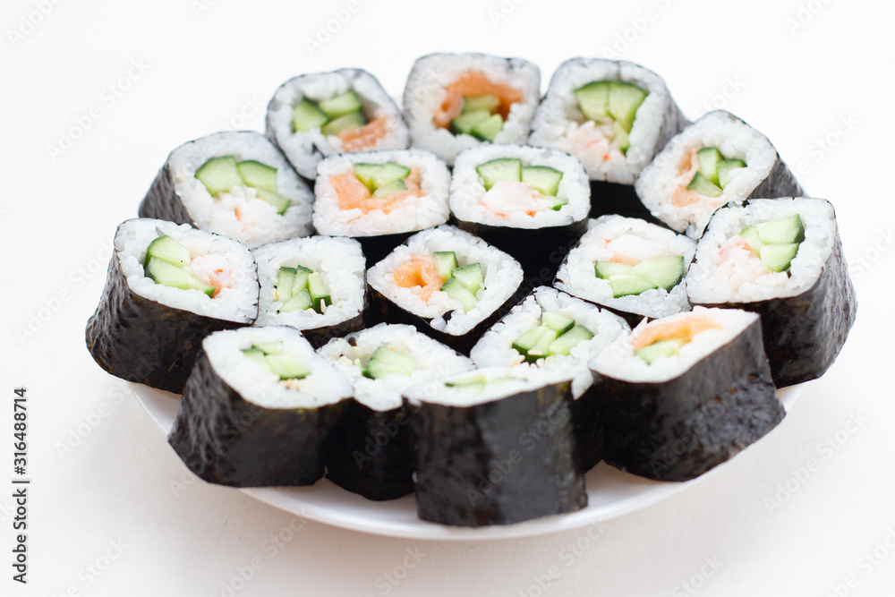 Japanese set of sushi rolls on white plate.