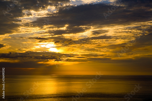 Colorful golden sunset and cloudy sky at the sea.
