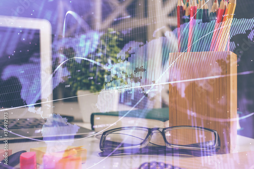 Financial chart hologram with glasses on the table background. Concept of business. Double exposure.