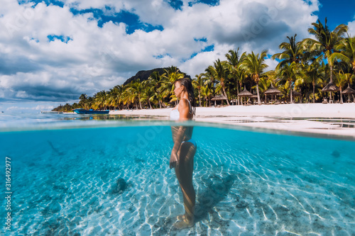 Woman posing in transparent blue ocean. Swimming in blue water at Mauritius