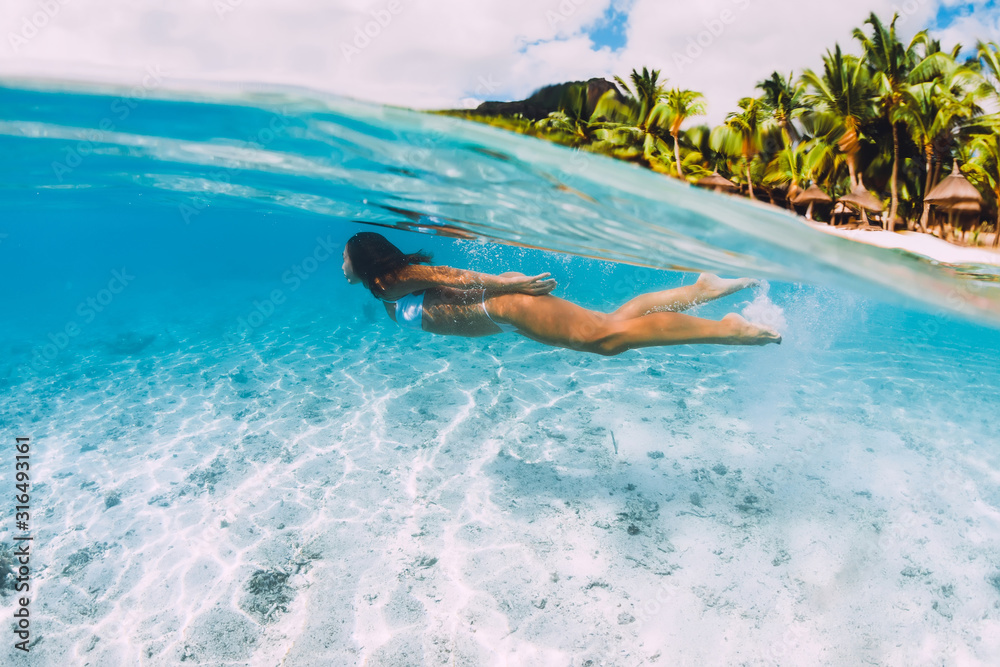 Woman swimming underwater in transparent blue ocean at Mauritius, Le Morne