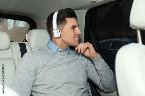Handsome man listening to audiobook in car © New Africa