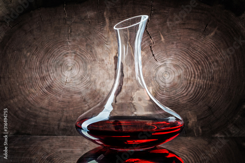 classic decanter with red wine on wooden background